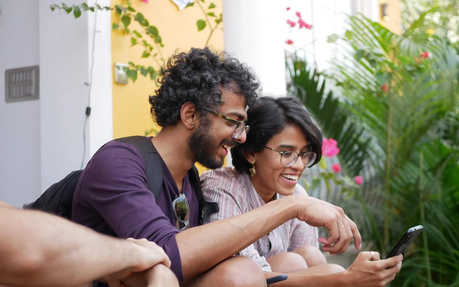 man in black polo shirt sitting beside woman in purple shirt